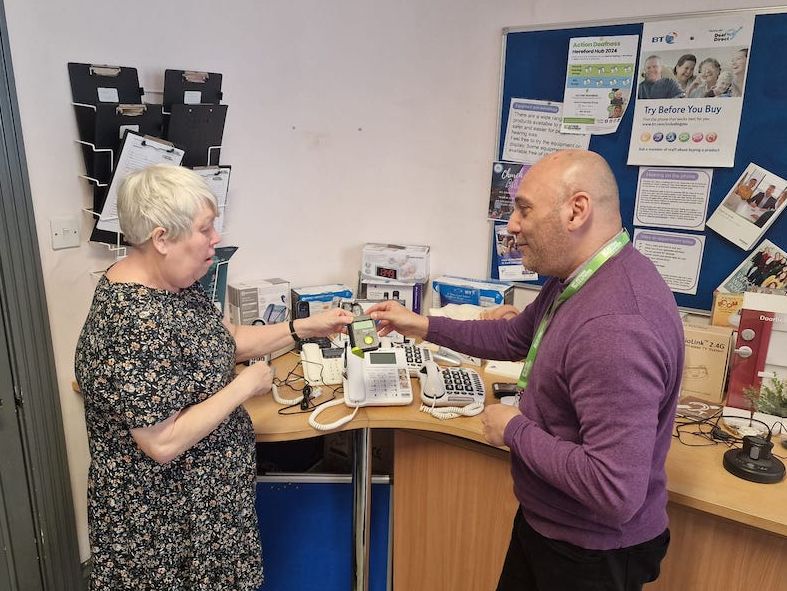 Photo of AD staff asking questions to another person with equipment in background